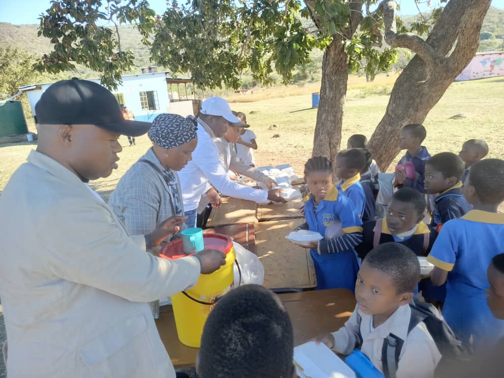Volunteers planting trees and distributing supplies in a Swazi village